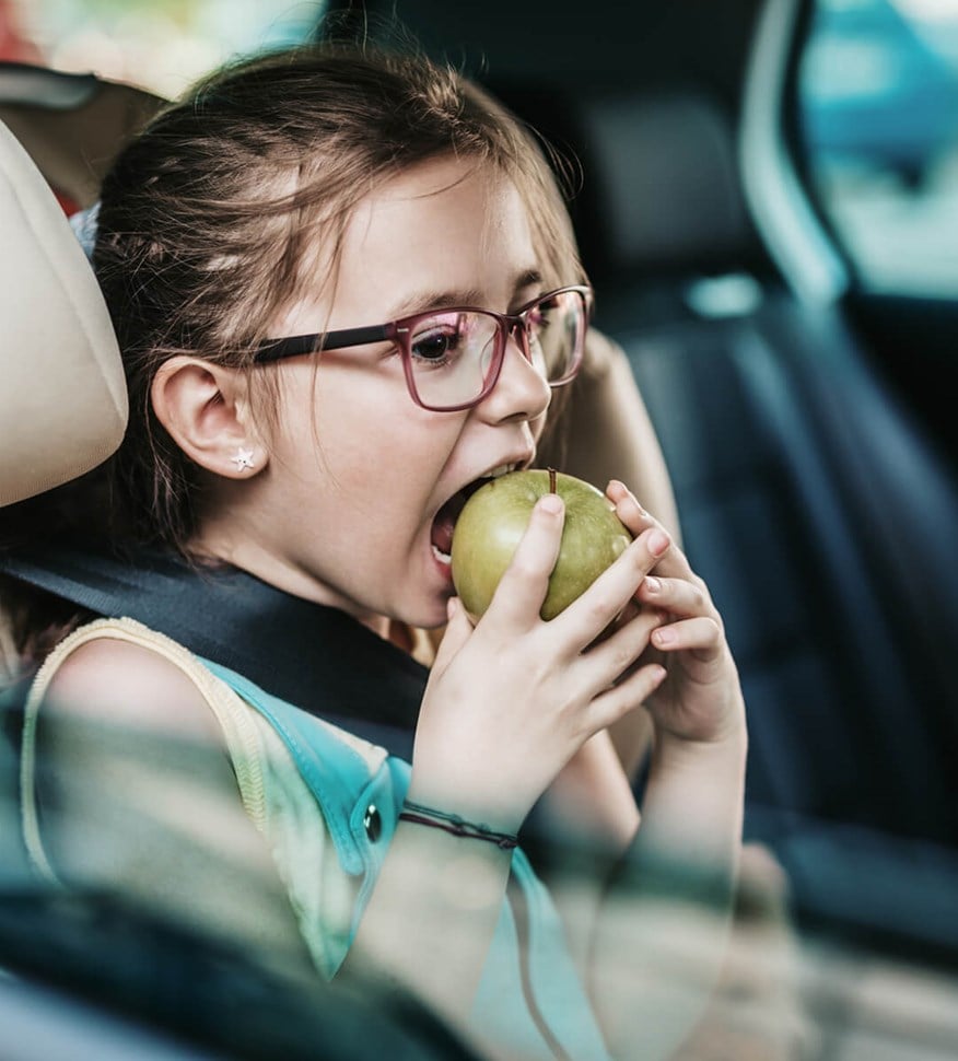 Bild av barn som äter äpple i bil